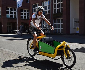 Ein Mann fährt auf einem Lastenfahrrad.