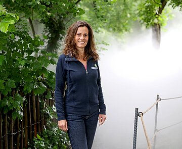 Architektin Anja Wurm steht mitten im Nebel des Farngartens.