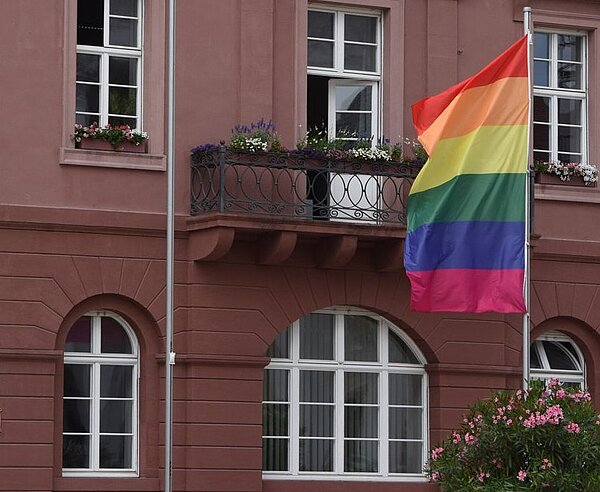 Eine Regenbogenflagge weht vor dem Karlsruher Rathaus.