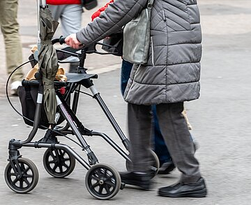 Mensch mit Rollator läuft durch die Innenstadt