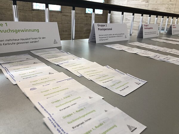 Tisch mit Karten zur Zuordnung der Teilnehmenden in die Arbeitsgruppen der Veranstaltung