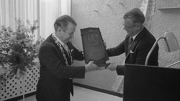 Oberbürgermeister Otto Dullenkopf mit Amtskette bei der Entgegennahme des Europapreises aus den Händen von André Radius, Ausschusspräsident des Europarats