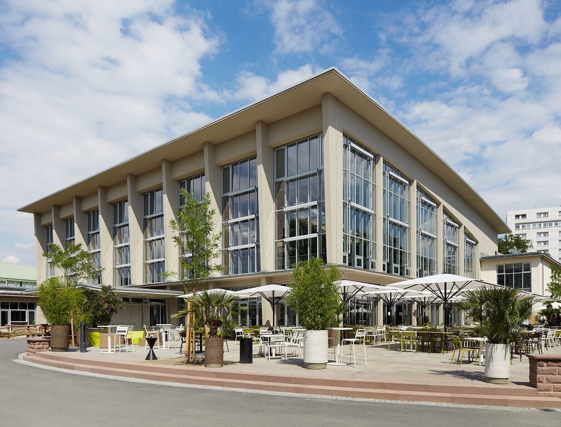 Blick auf die Südwestfassade mit großen Fenstern und einer Außenterrasse für Gäste.