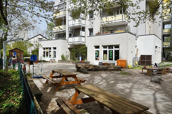 Gebäudeansicht Kita Ellmendinger Straße mit Spielplatz im Vordergrund