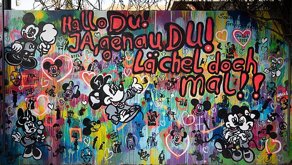 Eine neugestaltete Wand im Weiherhofgrünzug mit der Aufforderung zu Lächeln