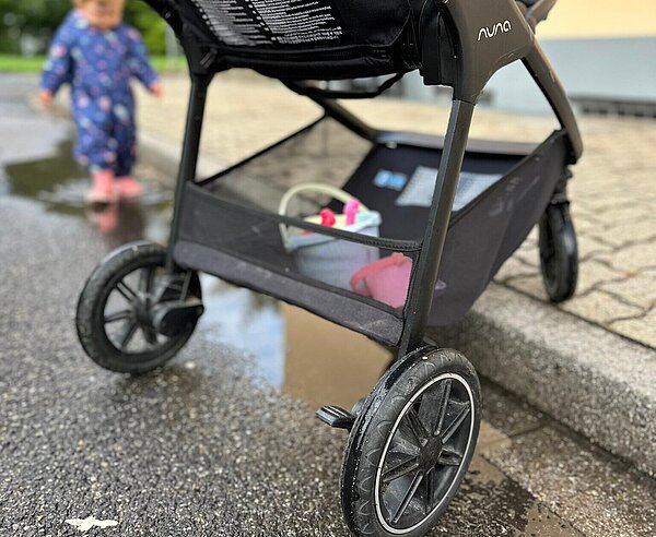 Ein Kinderwagen ist in der Stadt unterwegs.