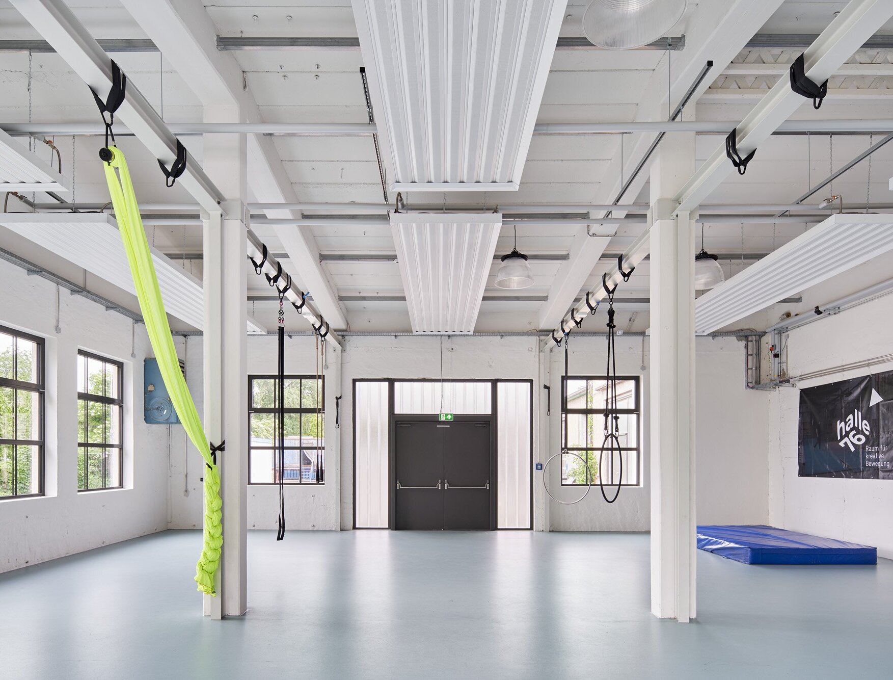 Zu sehen ist einer der Bewegungsräume mit Kautschukboden und Deckenbefestigungen für Turnübungen.