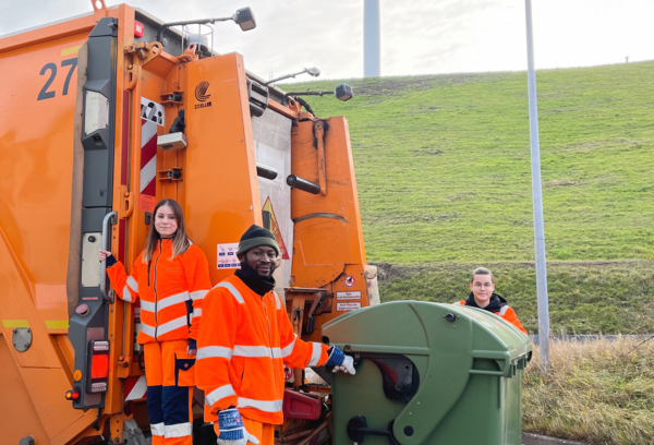Drei Auszubildende am Müllwagen