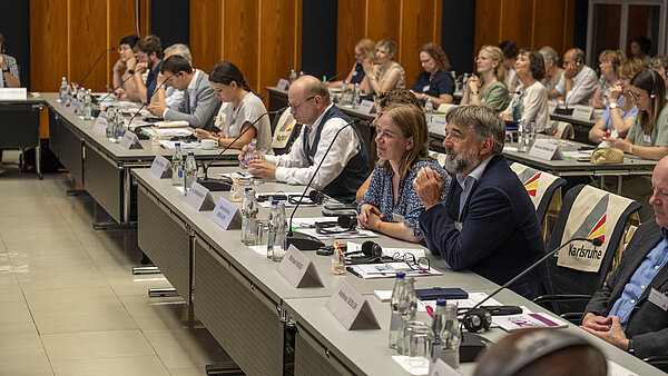 Blick in Tischreihe an denen Stadträtinnen und Stadträte sitzen