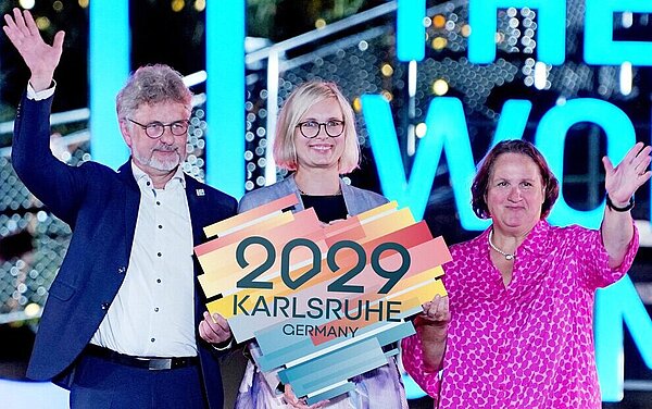 Oberbürgermeister Dr. Frank Mentrup, Dr. Christiane Schenderlein (Mitte), Staatsministerin für Sport und Ehrenamt und Theresa Schopper, Sportministerin Baden-Württemberg, bei der Flaggenübergabe in Chengdu.