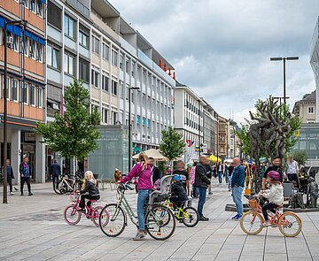 Passanten und Radfahrer vorm Lammbrunnen in der Fußgängerzone