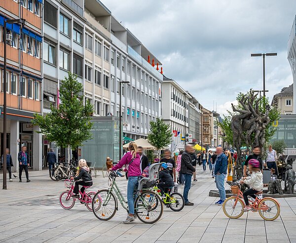Passanten und Radfahrer vorm Lammbrunnen in der Fußgängerzone