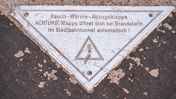 Die Markierung zeigt: "Achtung! Klappe öffnet sich bei Brandalarm im Stadtbahntunnel automatisch!"
