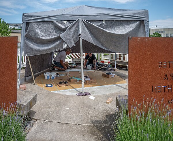 Reparaturarbeiten am Mosaik für die jüdische Religionsgemeinschaft im Garten der Religionen.