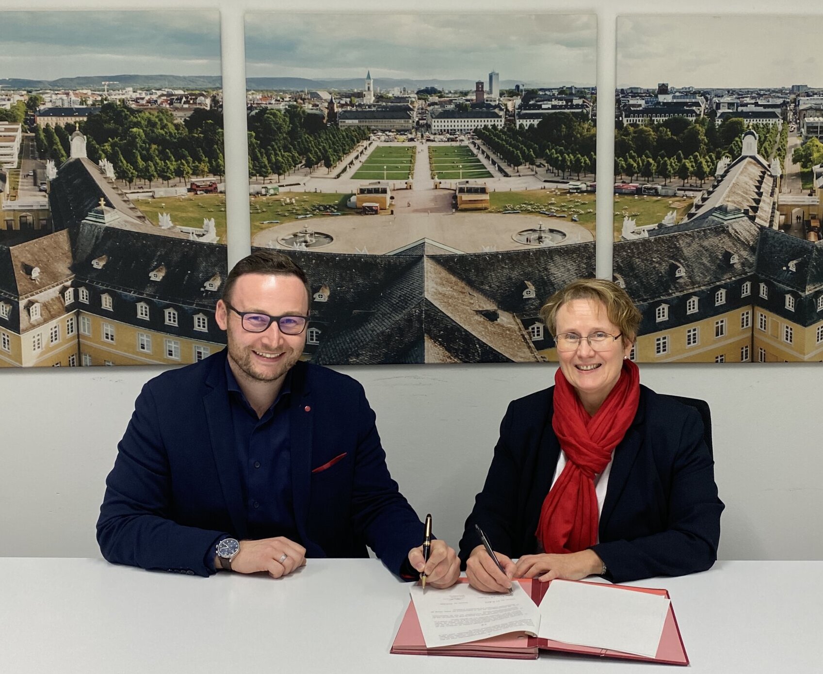 Pascal Rastetter (links) unterzeichnet im Beisein von Erster Bürgermeisterin Gabriele Luczak-Schwarz seinen Vertrag als neuer Geschäftsführer der KTG Karlsruhe Tourismus GmbH.