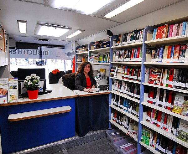Eine Mitarbeiterin steht hinter dem Tresen im Medienbus.
