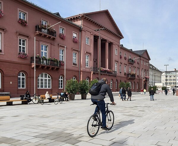 Marktplatz mit Rathaus mit Blick Richtung Norden bei gutem Wetter mit Personen und Radfahrer