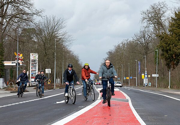 Bürgermeister Daniel Fluhrer (3.v.r.) testet die neue Querungshilfe auf der Willy-Brandt-Allee.