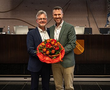 Oberbürgermeister Dr. Frank Mentrup übergibt Benjamin Bauer einen Blumenstrauß zur Verabschiedung