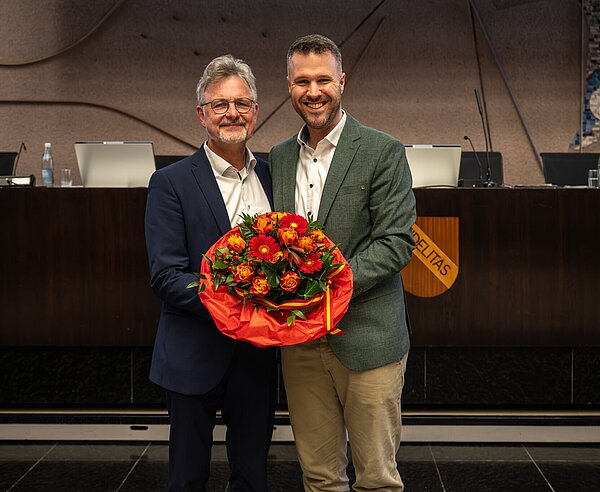 Oberbürgermeister Dr. Frank Mentrup übergibt Benjamin Bauer einen Blumenstrauß zur Verabschiedung