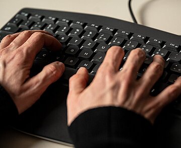 Hände tippen auf einer Tastatur
