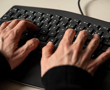Hände tippen auf einer Tastatur