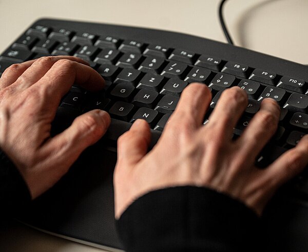 Hände tippen auf einer Tastatur