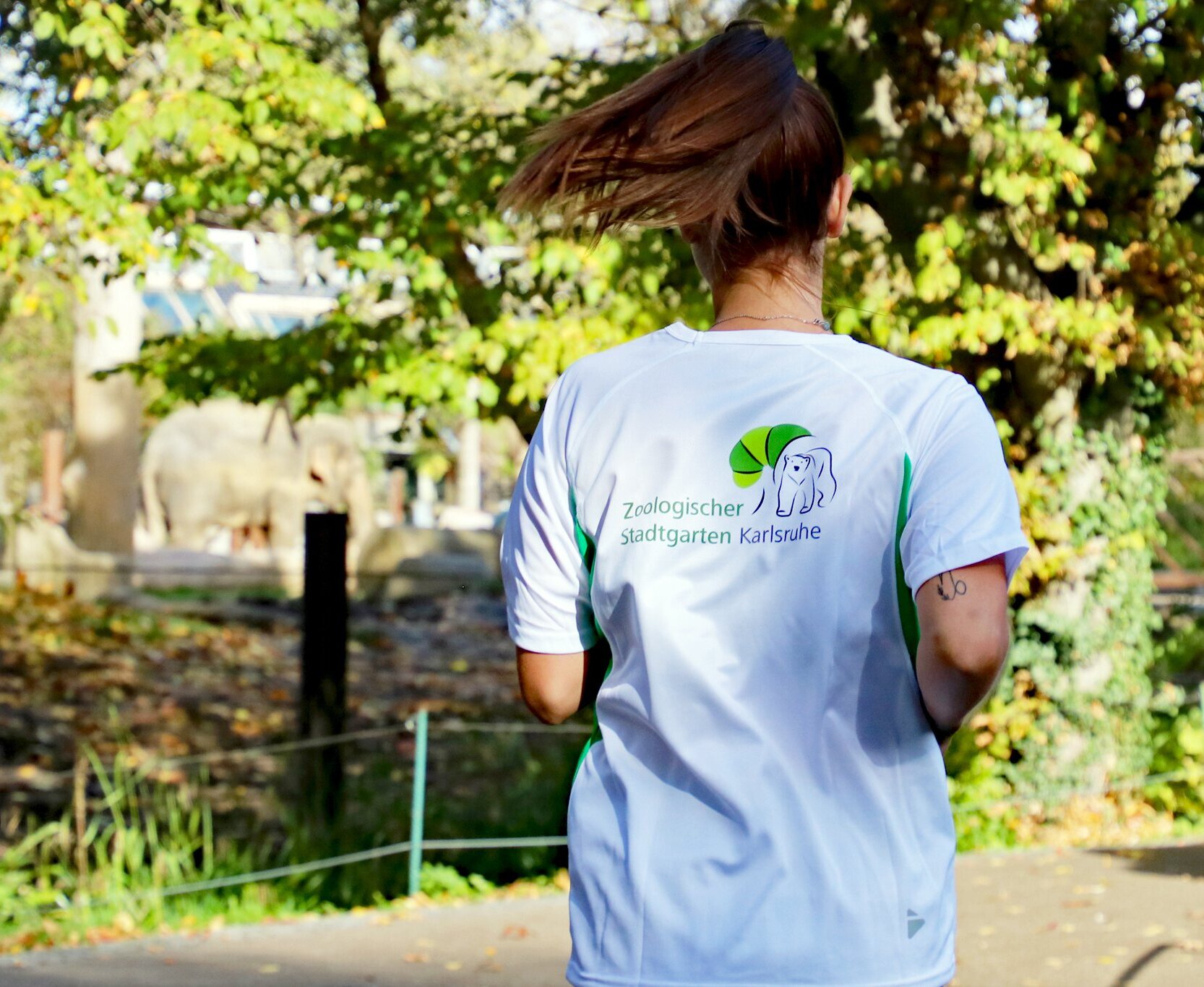 Eine Läuferin zeigt ihr T-Shirt mit der Aufschrift "Artenschutzlauf".