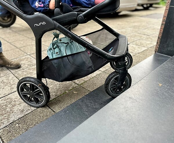 Ein Kinderwagen ist in der Stadt unterwegs.