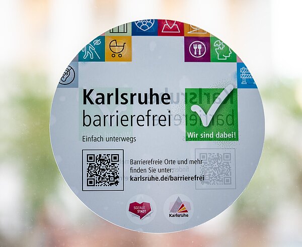 Aufkleber an der Eingangstür vom Rathaus weist auf die Barrierefreiheit und Barrierefreie Orte in Karlsruhe hin.