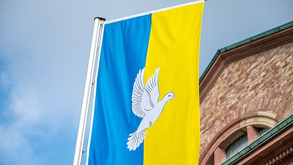 Frieden-und Ukraine Fahne wehen im Wind vor  der Kirche St.Stephan