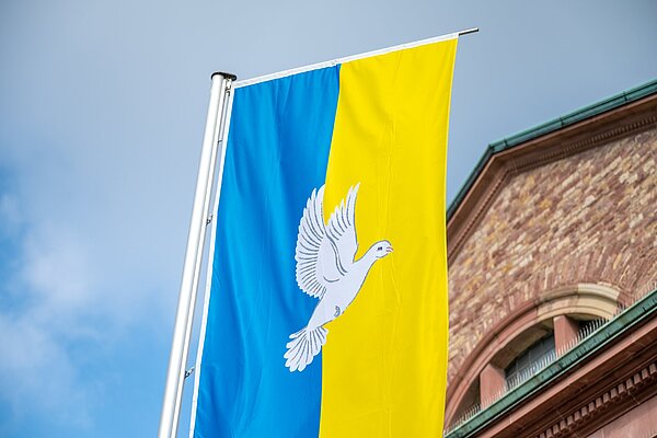 Frieden-und Ukraine Fahne wehen im Wind vor  der Kirche St.Stephan