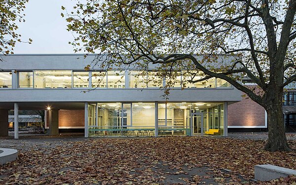 Ein Abschnitt der teilweise verglasten Nordfassade, durch die man in der Schülerarbeitsraum blicken kann.