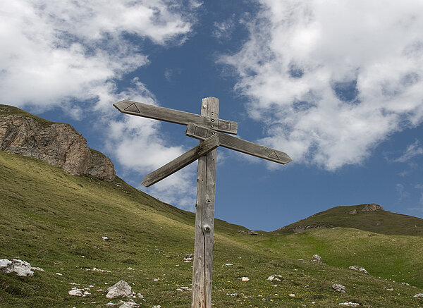 Wegweiser auf einem Bergpfad.