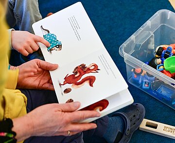 Kinder und Erzieher lesen gemeinsam ein Buch