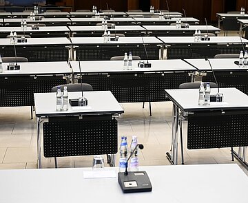 Einzelne Tische mit Mikrofonen im Bürgersaal