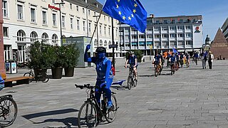Radfahrende mit Europafahne auf dem Marktplatz Karlsruhe