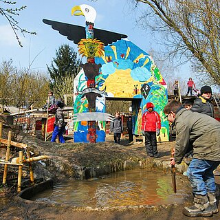 Das Bild zeigt spielende Kinder an einer Wasserstelle auf dem Aktivspielplatz.