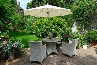 Sonnenschirm und Sitzecke im Garten 