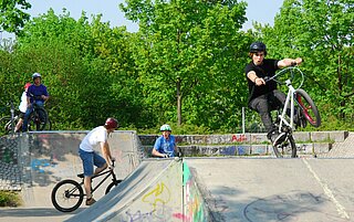 Das Bild zeigt Jugendliche mit ihren Fahrrädern auf dem Parcour des Skateplatzes in der Günther-Klotz-Anlage.