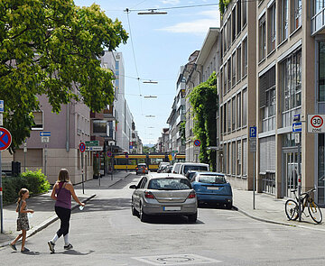 Mobilitätsverhalten in Karlsruhe - Das Bild zeigt eine Verkehrssituation mit zu Fuß Gehenden und Fahrzeugen.