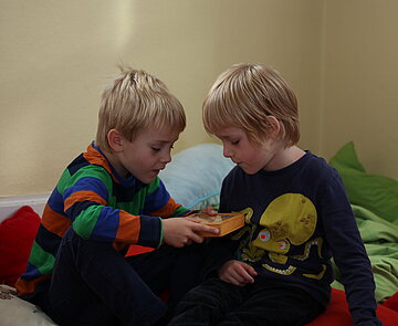 Zwei Grundschulkinder spielen in der Sitzecke