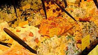 Das Bild zeigt eine Verkaufstheke mit verschiedenen Frischkäse-Sorten.