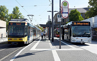Das Foto zeigt eine Haltestelle mit Bus und Bahn