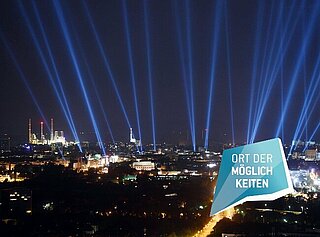 Luftbild von Karlsruhe bei Nacht mit Lichtkegeln.