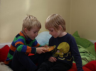 Zwei Grundschulkinder spielen in der Sitzecke