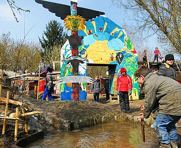Das Bild zeigt spielende Kinder an einer Wasserstelle auf dem Aktivspielplatz.