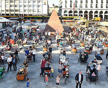 Das Foto zeigt Bürgermeister Fluhrer zusammen mit 113 Familien und ihren Lastenrädern auf dem Marktplatz in Karlsruhe.