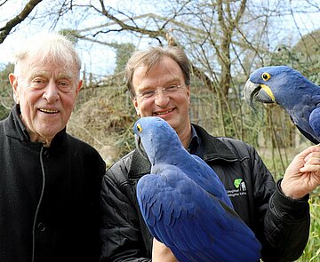 Theaterregisseur Claus Peymann beim Treffen mit Zoodirektor Dr. Matthias Reinschmidt und den beiden Hyazinth-Aras Henry und Indigo
