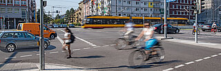Auf dem Foto ist eine Straßenkreuzung mit diversen Verkehrsteilnehmenden zu sehen